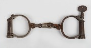 Antique handcuffs with remains of nickel plated finish and&nbsp;screw key, 19th century, ​​​​​​​26cm wide.