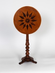 An antique Australian tilt-top wine table with baluster turned cedar column and tri-footed base, circular huon pine top with decorative lozenge starburst inlay, 19th century, 73cm high, 47cm diameter