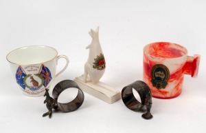 SOUVENIR WARE: A porcelain kangaroo with an Australian Commonwealth Military Forces transfer, a pair of EPNS kangaroo mounted napkin rings, 1927 Opening of Parliament House teacup, 1938 Sesquicentenary bakelite cup, (5 items).
