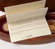 2001 AUSTRALIAN PROSPECTOR COLLECTION from The Perth Mint: comprising of the $100 (1oz) Prospector panning pure gold coin, an uncirculated 1931P Sovereign,&nbsp;and several loose Gold Nuggets weighing 7.88 grams. All presented in an oval-shaped timber case fea - 2