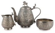 An antique Indian silver three piece tea service, decorated with palm trees and wild animals, 19th/20th century, the teapot 15cm high, 515 grams total
