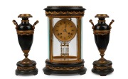 An antique French three piece library clock set, oval cased four glass clock with applied ormolu floral decoration and black patinated plinth with match top, the urn side pieces similarly decorated, time and gong striking eight day movement with mercury f