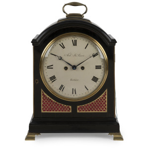 An antique English spring table clock in ebonized fruitwood case with brass bound single pad top and bail carrying handle, fish scale sound frets, standing on bracket feet. Original convex painted enamel dial with Roman numerals and maker's details "ARCH' JON' CURRIE, London". Blue steeled bregette style moon hands with strike/no strike lever above the 12. Eight day time and bell striking fusee movement with trip repeat and verge escapement. Back plate with wavy border decoration, circa 1805.