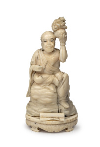 An antique Japanese carved marine ivory and whalebone statue of a seated scholar holding an infant dragon, Meiji period, 19th century, 12.5cm high.