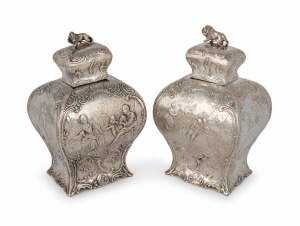 A pair of antique Dutch silver tea caddies with repousse decoration and lion finials, 19th century, 14cm high, 418 grams.