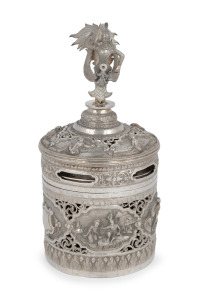 A Burmese circular lidded box with ornate repousse decoration and well cast figural finial, 19th/20th century, 23cm high, 604 grams total