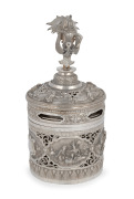 A Burmese circular lidded box with ornate repousse decoration and well cast figural finial, 19th/20th century, 23cm high, 604 grams total