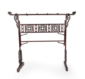 A Chinese stained hardwood hanging rack with scroll supports, fretted central rail and stylised bird head hanging posts, 20th century, 186cm high, 213cm wide, 55cm deep.