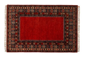 A Persian hand-knotted rug on red ground with bound fringe, 193 x 131cm