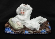 An antique hand-painted German porcelain figurine of Gaultier on a bear skin rug, circa 1880, 20cm long