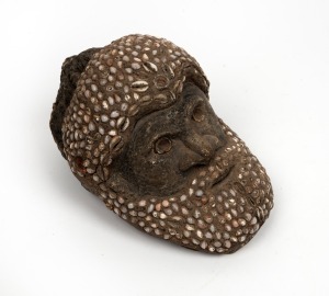 A tribal&nbsp;totem figure of a mans head, carved stone, clay and shell, Papua New Guinea origin, unknown age,&nbsp; collected in 1968, 14cm high, 21cm long&nbsp;