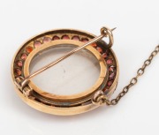 An antique 15ct gold circular brooch with garnet bezel and photo or mourning window, 19th century, ​​​​​​​2.5cm diameter, 7.8 grams including glass. - 2
