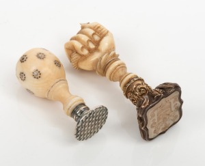 Two antique carved ivory seals, one with inlaid cut steel, the other handsomely carved in the form of a fist, 18th/19th century, 4cm and 5cm high.