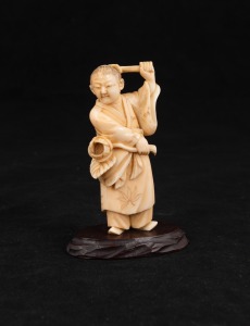 An antique Japanese carved ivory standing figure with flower mounted on later timber base, Meiji Period, 19th/20th century, 10cm high overall