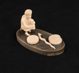 An Indian carved ivory snake charmer figural group mounted on horn plinth, mid 20th century, 6cm high, 10cm wide