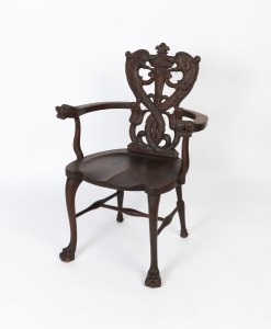 An antique English oak armchair with dolphin head terminals to the rests, marine grotesque, pierced and carved lyre back supports, united by a turned H stretcher with slender front cabriole legs standing on lions paw feet, circa 1900, 97cm high, 65cm acro