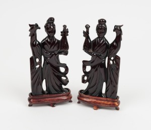 A pair of Chinese carved amber statues on timber bases, 19th/20th century, 15cm high overall