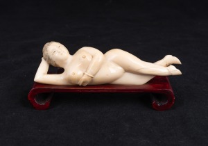 A Chinese carved ivory doctor's model of a female nude on carved timber base, 20th century, 13cm long