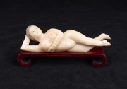 A Chinese carved ivory doctor's model of a female nude on carved timber base, 20th century, 13cm long