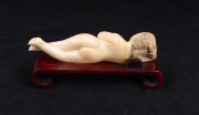 A Chinese carved ivory doctor's model of a female nude on carved timber base, 20th century, 13cm long - 2