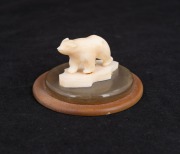 An Inuit carved marine ivory polar bear statue mounted on horn plinth, 20th century, 4cm high, 7cm diameter