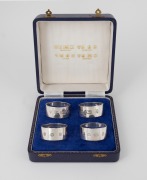 A boxed set of four English sterling silver napkin rings, attractively displayed with explanatory gilt inscriptions, ​​​​​​​122 grams total