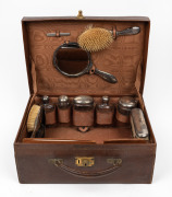 An antique sterling silver topped vanity set housed in original fitted brown leather travel case, early 20th century, ​​​​​​​the case 40cm wide