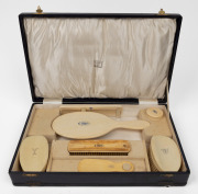 A boxed travelling vanity kit crafted in ivory with ownership monograms to top, late 19th century, the case 42cm wide