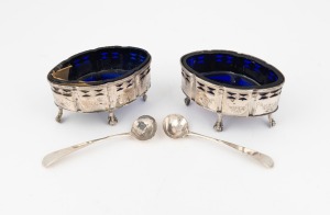 A pair of Georgian sterling silver condiment pots with original blue glass liners (damaged), London made, circa 1789; together with a pair of Georgian sterling silver condiment spoons, (4 items), 9cm wide, 124 grams total silver weight
