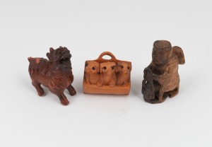 A Japanese carved boxwood netsuke of three puppies with inset glass eyes, together with two Chinese carved wooden miniature ornaments, 19th/20th century, (3 items), the largest 5cm high.