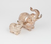 Two Burmese silver elephant boxes, both with raised trunks, ​​​​​​​the larger 14cm high, 335 grams.