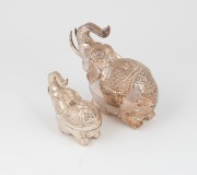 Two Burmese silver elephant boxes, both with raised trunks, ​​​​​​​the larger 14cm high, 335 grams. - 2