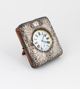 An antique oversized nickel plated pocket watch with crown wind movement, Roman numerals and subsidiary seconds dial, housed in an antique sterling silver and leather travel case (the case poor condition), the watch 9.5cm high overall including bow