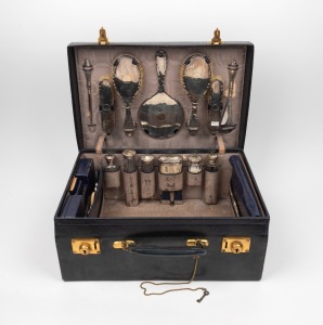 104 · An antique sterling silver topped vanity set housed in original fitted blue leather travel case, early 20th century, the case 48cm wide