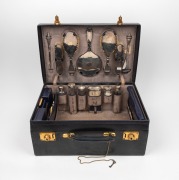 An antique sterling silver topped vanity set housed in original fitted blue leather travel case, early 20th century, the case 48cm wide