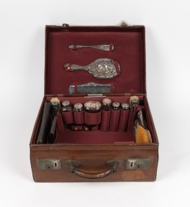 97 · An antique travelling case with sterling silver topped accessories, early 20th century, ​​​​​​​the case 43cm wide.
