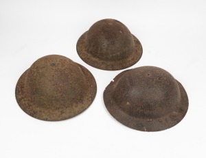 Two British infantry helmets; together with an air raid warden's helmet, (3 items)
