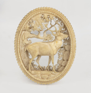 An antique carved deer antler brooch, impressively adorned with stag in landscape, 19th century, 5cm high