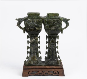A Chinese carved jade double vase on carved timber stand, executed in the Archaic style, 19th/20th century, 27cm high overall