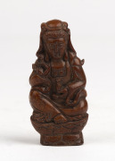 A carved stone seated Guanyin Buddhist figure, 19th century, holed on the top to be suspended as an amulet, 7cm high