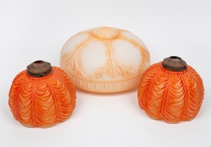 A pair of vintage orange glass light shades, together with an antique orange finished milk glass oil lamp shade, 19th/20th, (3 items), the largest 28cm wide