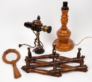 A turned parquetry timber lamp base, a concertina expanding hat rack, an attractively carved timber hand-mirror and an unusual projector lamp, 19th and 20th century, (4 items), the largest 38cm high