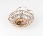 ROYAL WORCESTER antique English porcelain plaque of a flying duck by STINTON, mounted into the base of a sterling silver pierced bonbon basket, puce factory mark to base, ​​​​​​​9cm high, 11cm wide overall.