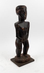 A male tribal totem statue, carved wood with remains of ebonised finish, unknown age and origin, 60cm high