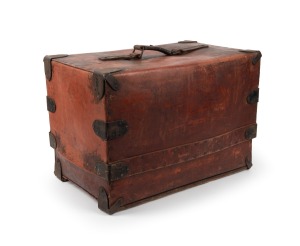 An antique American raw hide travel trunk with slip case lid and leather straps, bearing original maker's label, 19th century, ​​​​​​​35cm high, 55cm wide, 35cm deep.