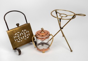 A folding brass fireside trivet; together with an unusual antique wall mounted brass trivet with iron bracket and an ice bucket mounted in copper and brass, 19th/20th century, (3 items), the largest 30cm high