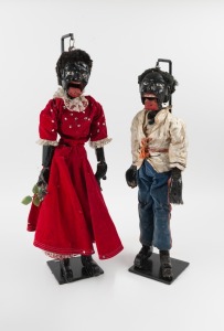Two rare Black Americana "Slave Dolls", carved and painted timber with hand-made costumes, mid 19th century, with bespoke museum stands, the larger 60cm high