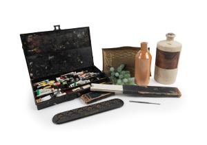 A vintage black metal artist's box with paints (used); together with a metal calculator, vintage boxed rule, two stoneware chemical jars, an Arts & Crafts brass tray and Murano glass grapes, 19th and 20th century, (8 items), ​​​​​​​the artist's box 32cm w