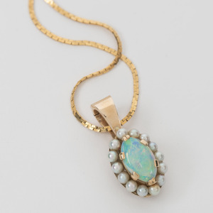 A vintage 9ct gold pendant with solid opal surrounded by seed pearls, suspended on a 14ct fine gold chain, 20th century, the pendant 2.3cm high, the chain 42cm long, 6.1 grams total.