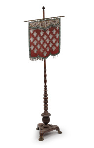 A Georgian banner pole, turned mahogany with lion paw brass feet and beadwork banner, early 19th century, 150cm high